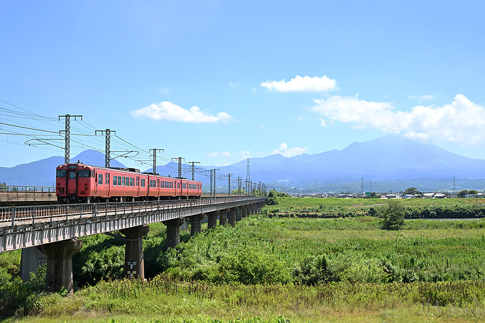 Kiha40 series ordinary diesel train crossing a railroad bridge with Mt. Taken at Hoki Daisen Station   Higashiyama Koen Station