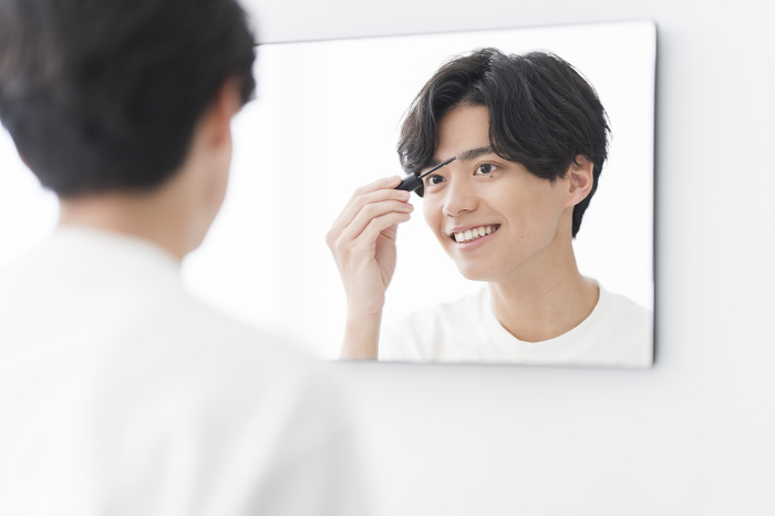 Lifestyle of a young Japanese male who puts on his makeup while looking in the mirror (People)