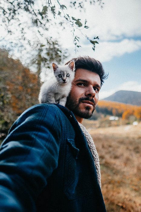 Tiny kitten sitting on man shoulder in the nature, Cheia, Prahova, Romania, by Cavan Images / Buduleanu Emanuel Andrei