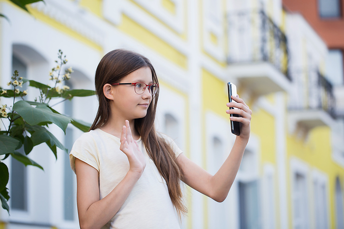 A teenage girl communicates via video call on the street, Bila Tserkva, Kyiv Oblast, Ukraine, by Cavan Images / Iuliia Malivanchuk
