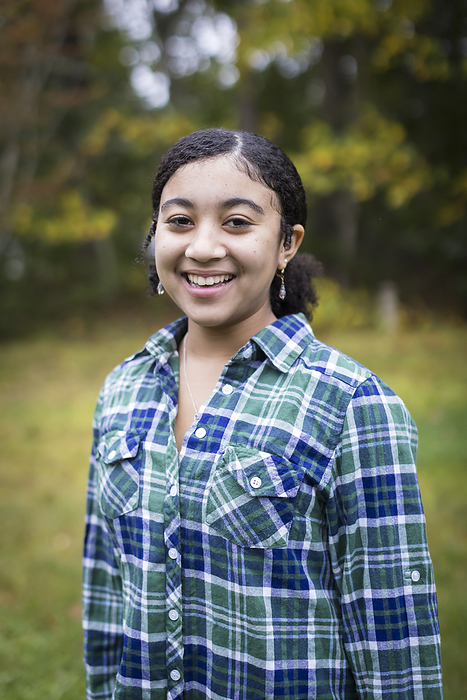 portrait of biracial teen girl smiling, Harwich, Massachusetts, United States, by Cavan Images / Julia Cumes