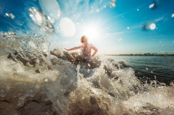 Boy playing in ocean waves as water crashes in, Coronado, California, United States, by Cavan Images / Kristen Ryan