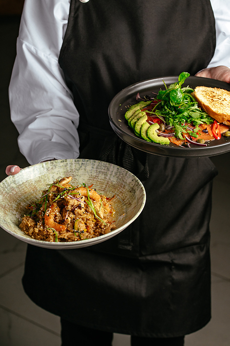 The waiter holds a plate of fried Chinese rice, Paris, Île-de-France, France, by Cavan Images / Aleksandr Kuzmin