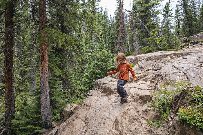 Girl scrambling down rocks in the Holy Cross Wilderness, Colorado, Leadville, Colorado, United States, by Cavan Images / Patrick Lienin