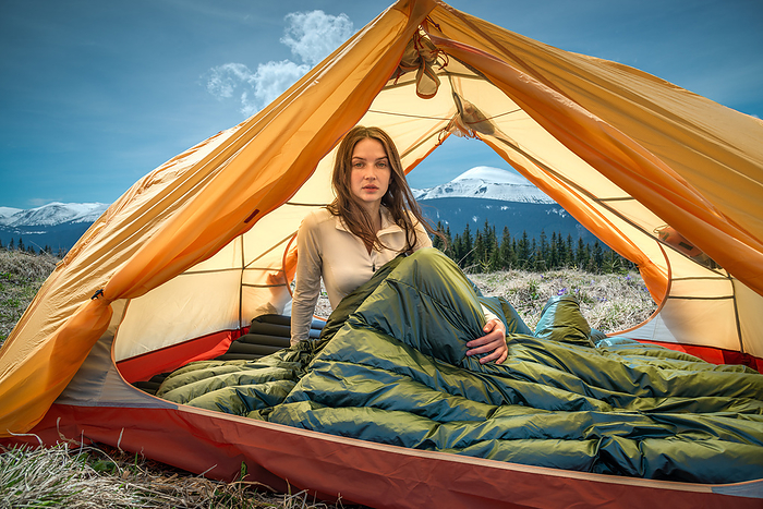 Young Woman Sitting in Tent in the Mountains, Ivano-Frankivsk, Ivano-Frankivsk Oblast, Ukraine, by Cavan Images / Artur Abramiv