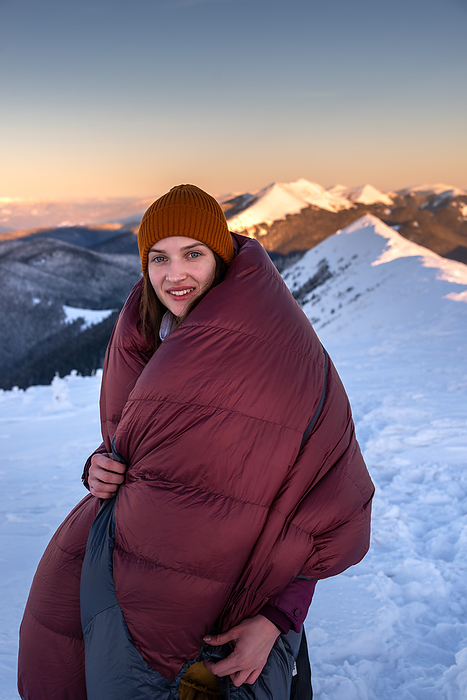 Portrait of Smiling Young Woman Wrapped in a Sleeping Bag, Bukovel, Ivano-Frankivsk Oblast, Ukraine, by Cavan Images / Artur Abramiv