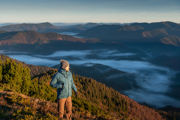 Hiker Alone Looking at View From Mountain Top, First Morning Light, Nehrovets', Zakarpattia Oblast, Ukraine, by Cavan Images / Artur Abramiv