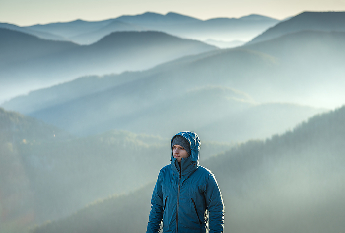 Serious Man in Blue Hooded Jacket Looking At Scenic View, Nehrovets', Zakarpattia Oblast, Ukraine, by Cavan Images / Artur Abramiv