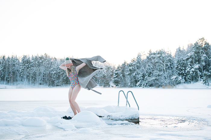 woman putting on a robe after taking a frozen water plunge, Stockholm, Stockholm County, Sweden, by Cavan Images / Rachel Bell