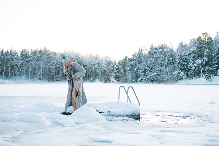 woman in a robe by the frozen baltic sea after a cold water plunge, Stockholm, Stockholm County, Sweden, by Cavan Images / Rachel Bell