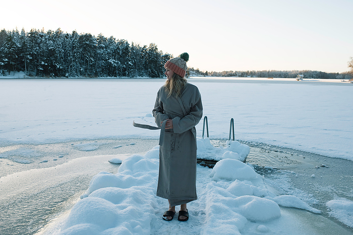 woman wrapped in a robe after cold water swimming in the baltic sea, Stockholm, Stockholm County, Sweden, by Cavan Images / Rachel Bell