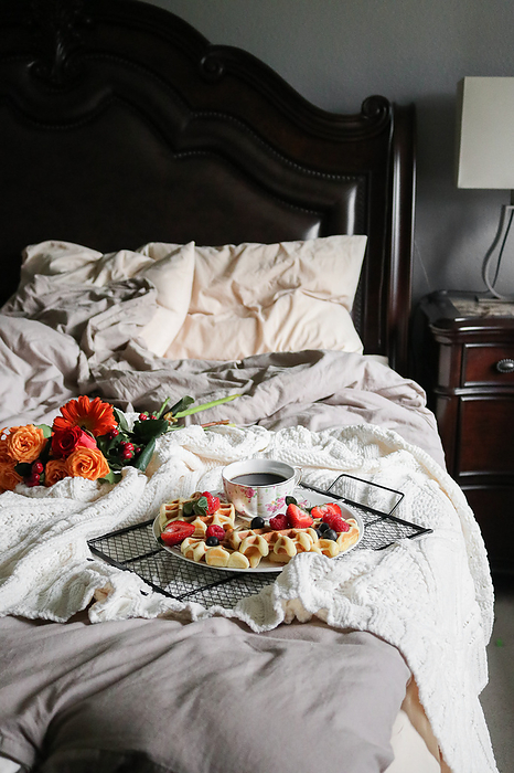 Waffles and coffee on a platter and flowers  for breakfast in bed, Seattle, Washington, United States, by Cavan Images / ELENA LEVCENCO