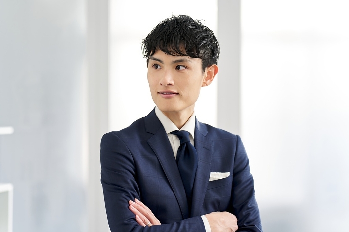 Japanese businessman wearing a custom-made suit and folding his arms (Male / People)