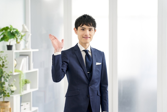 Japanese businessman wearing a custom-made suit giving an introduction (Male / People)