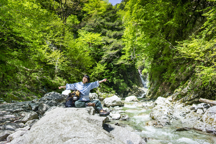 Young Japanese woman trekking/taking a break from the scenery in the canyon (People)