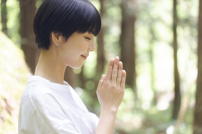 Japanese woman praying in the forest (People)