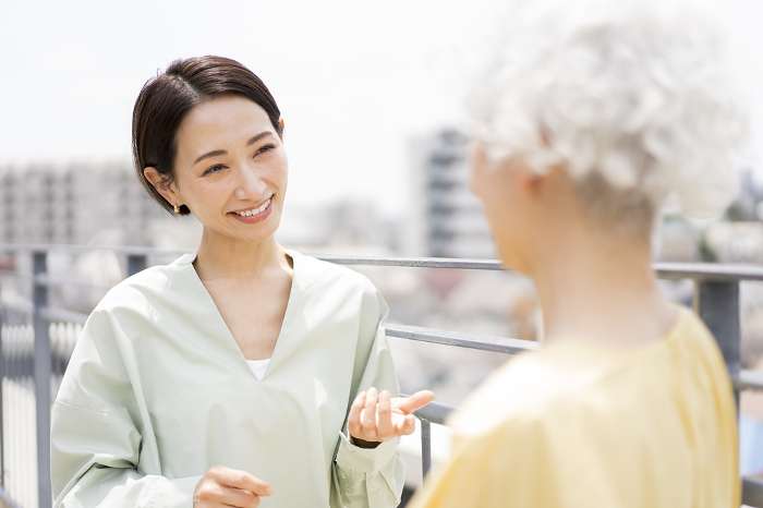 Two Japanese women standing talking.