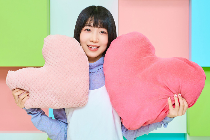 Young woman with heart-shaped cushion