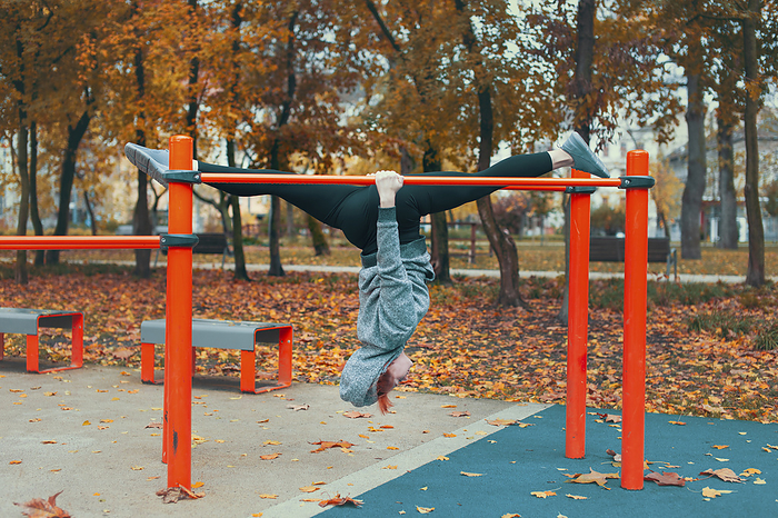 Woman doing inverted splits on bars in park Woman doing inverted splits on bars in park., by SAKKMESTERKE SCIENCE PHOTO LIBRARY