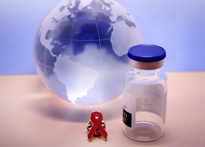 HIV vaccine, conceptual image Conceptual image showing an HIV  human immunodeficiency virus  vaccine bottle next to an HIV awareness ribbon in front of the globe. HIV infects and destroys human immune cells, and can lead to AIDS  acquired immunodeficiency syndrome . World AIDS day takes place every year on the 1st of December., by NATIONAL INSTITUTES OF HEALTH SCIENCE PHOTO LIBRARY