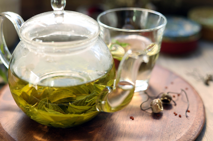 Mint tea brewed in a glass teapot