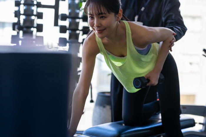 Young Japanese woman working out at a gym (People)