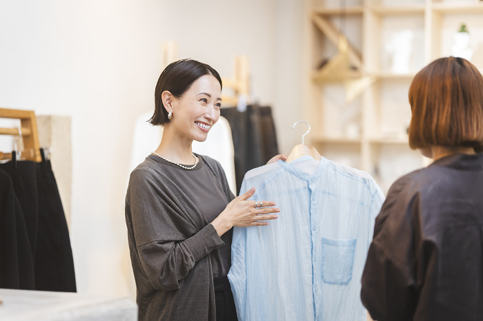 Working Japanese woman/apparel store employee serving customers (People)