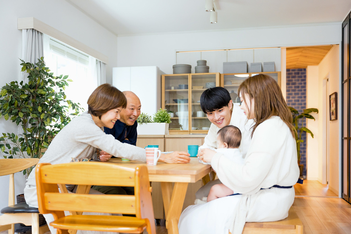 Grandfather and grandmother nursing their baby grandson at home (image of a family of three) (Japanese / People)