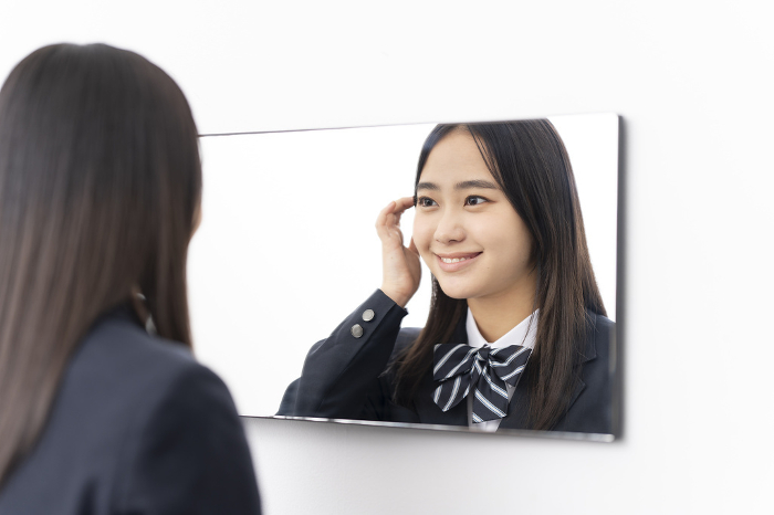 Japanese high school girl looking in the mirror.