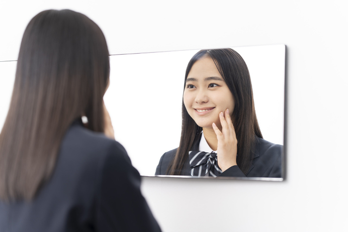 Japanese high school girl looking in the mirror.