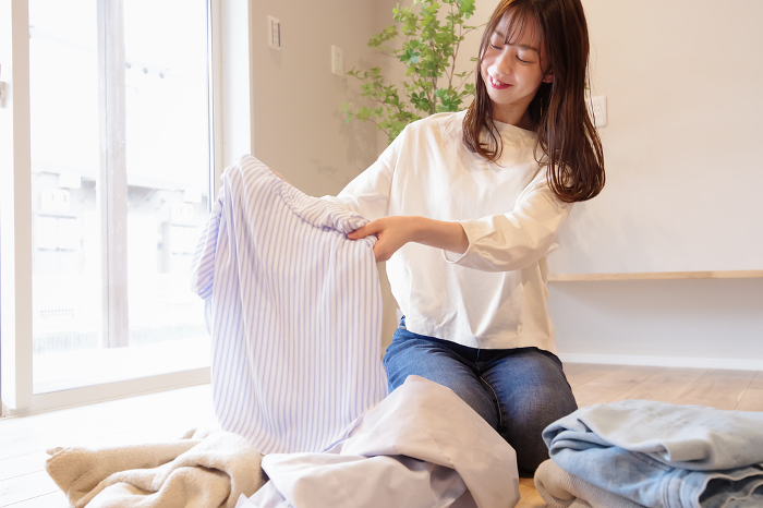 Young woman putting away laundry