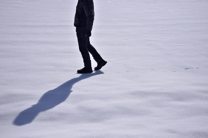 Man's feet walking on snow