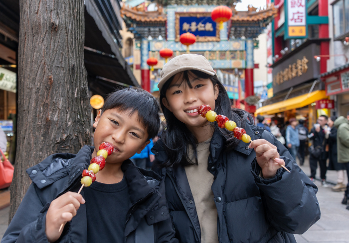 Japanese boy and girl eating strawberry candy in Yokohama Chinatown
