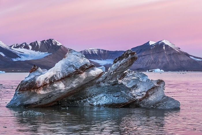 Ice berg shape Kongsfjorden in a unique abstract shape in the beautiful colorful sunrise light of the Arctic. Behind mountains of Svalbard Archipelago, Norway, Europe, by Anette Mossbacher