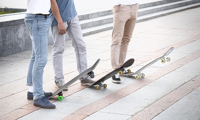 Group of skateboarders are standing near their boards and are preparing to begin training, by Andrei Zaretski