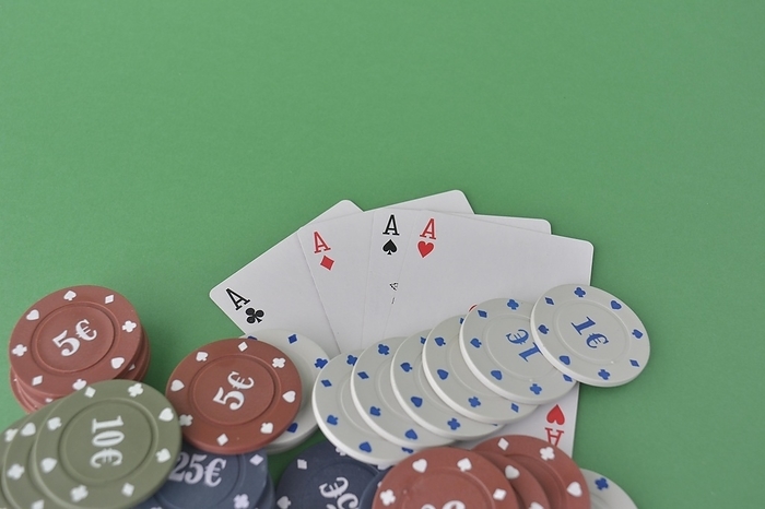 A hand of aces above neatly stacked poker chips on green felt, suggesting a winning game, poker cards and chips, by carlos l vives