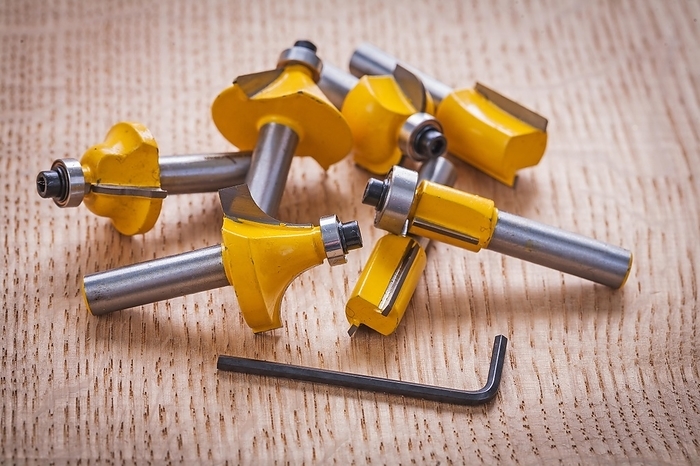 Stack of roundover router bits for woodworking on wooden board, by Dzmitri Mikhaltsow