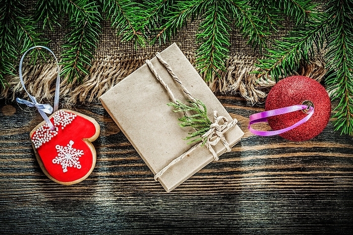 Pine tree branch bagging Christmas ball gingerbread gift box on wood board, by Dzmitri Mikhaltsow