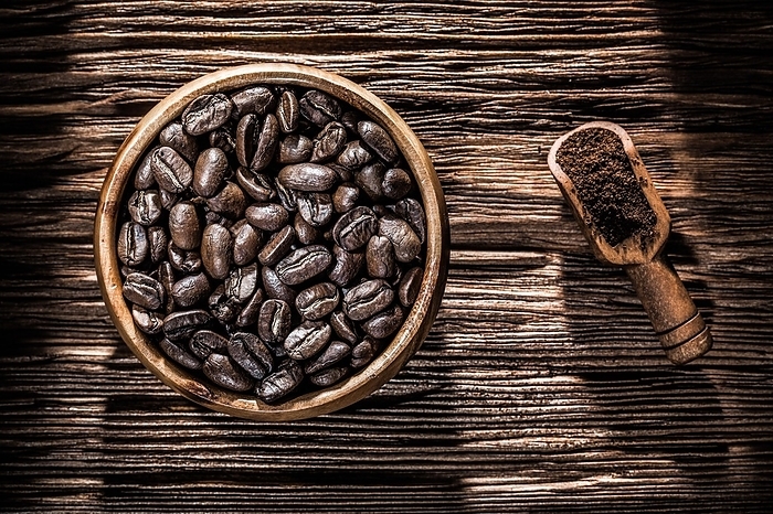 Bowl with ground coffee beans on a wooden board, by Dzmitri Mikhaltsow