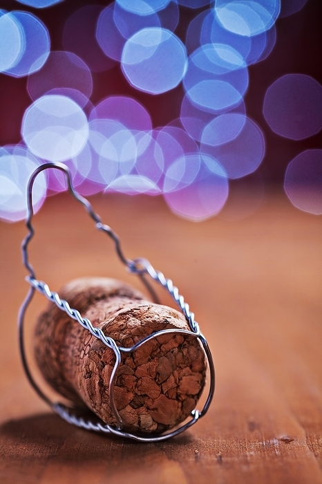 Corck for champagne on wooden table and blurred background, by Dzmitri Mikhaltsow