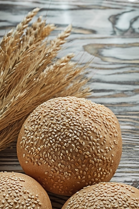 Bread bundle of wheat ears on vintage wood surface, by Dzmitri Mikhaltsow