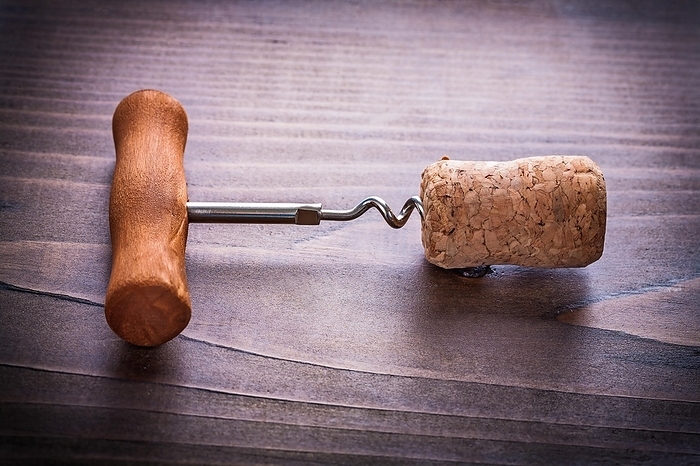 Corkscrew twisted in corks of champagne on vinatge wooden board close up alcohol concept, by Dzmitri Mikhaltsow