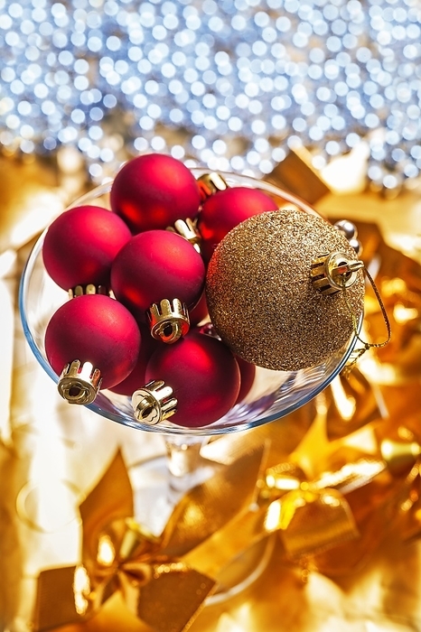 Golden and red Christmas baubles in a Martini wine glass, by Dzmitri Mikhaltsow