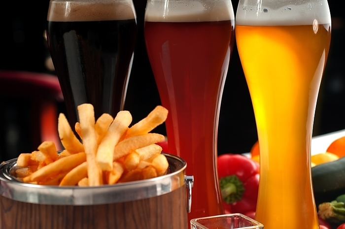Fresh french fries on a wood bucket with selection of beers and fresh vegetables on background, food photography, by keko64