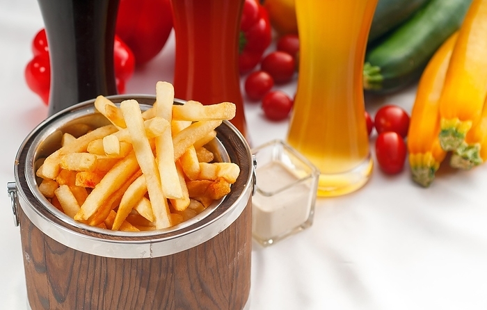 Fresh french fries on a wood bucket with selection of beers and fresh vegetables on background, food photography, by keko64