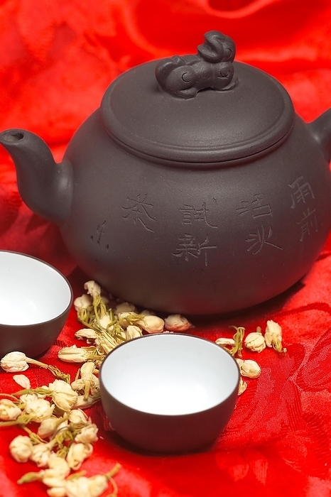 Jasmine tea dry flowers, pot and two cups, over red silk tablecloth, food photography, by keko64