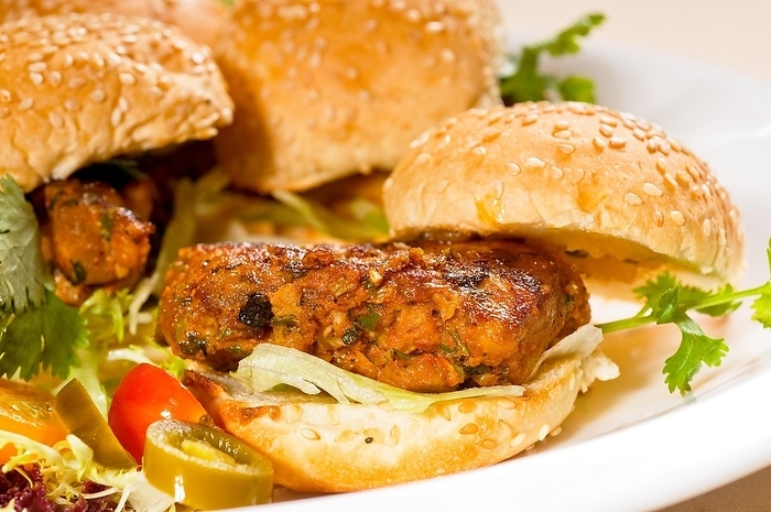 Four fresh and delicious mini chicken burgers on a plate, close up, food photography, by keko64