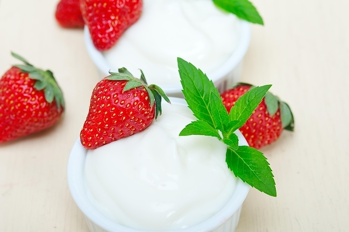 Organic Greek yogurt and strawberry over white rustic wood table, by Francesco Perre