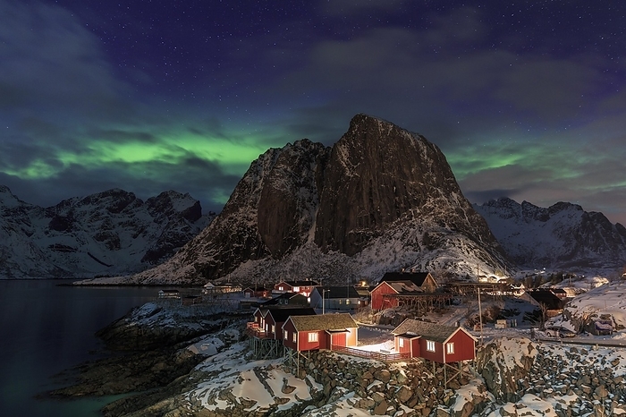 Northern Lights or Aurora Borealis over red rorbuer, fishermen's cabins, winter, snow-capped mountains behind, Hamnøy, Lofoten, Nordland, Norway, Europe, by Manfred Schmidt
