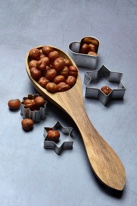 Wooden ladle with hazelnuts, cookie cutters, baking ingredient, by Jürgen Pfeiffer